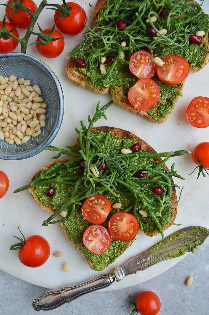 Two toasts with basil & kale pesto, samphire, tomatoes and pomegranate