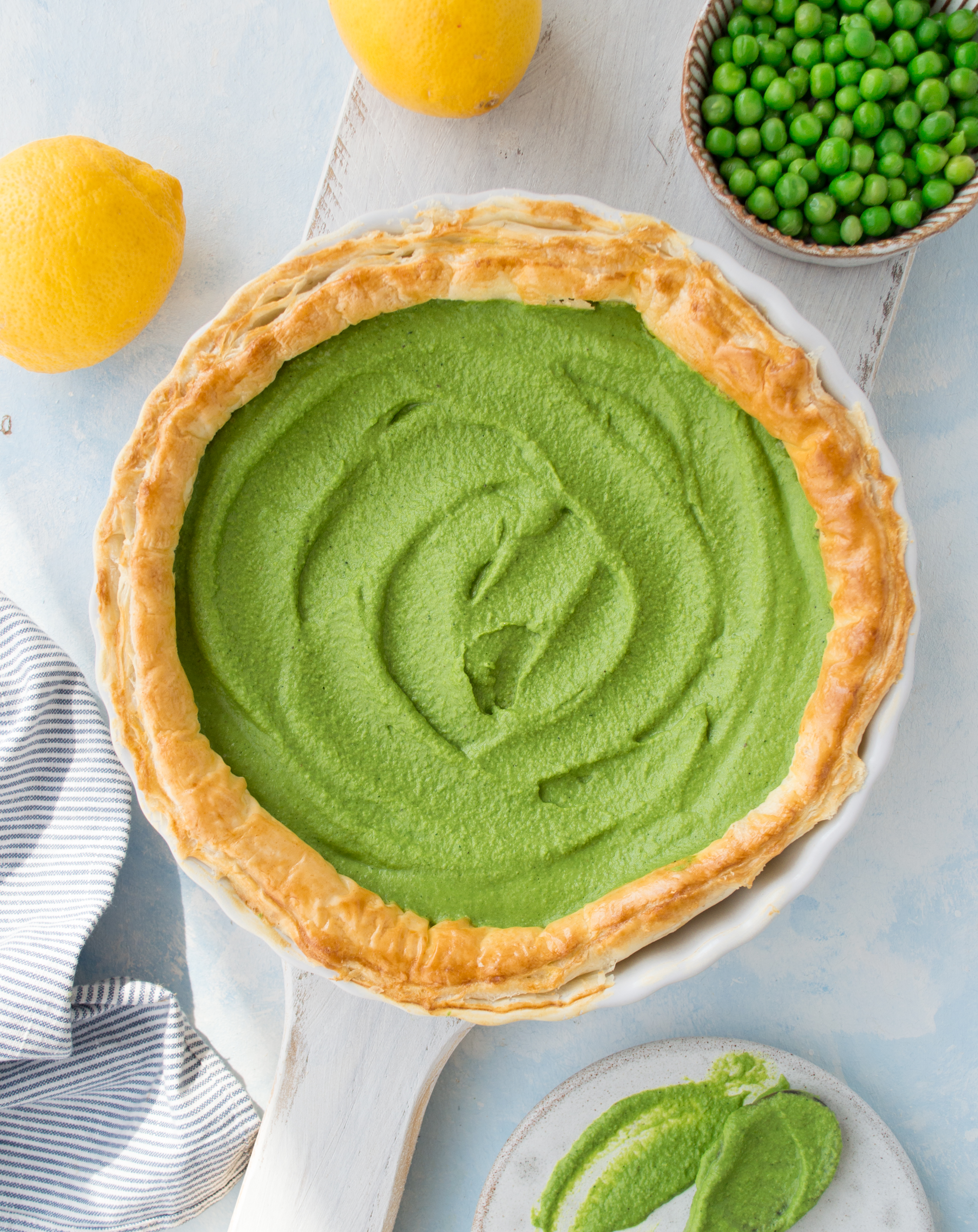 Overhead shot of pastry tart, filled with green pesto