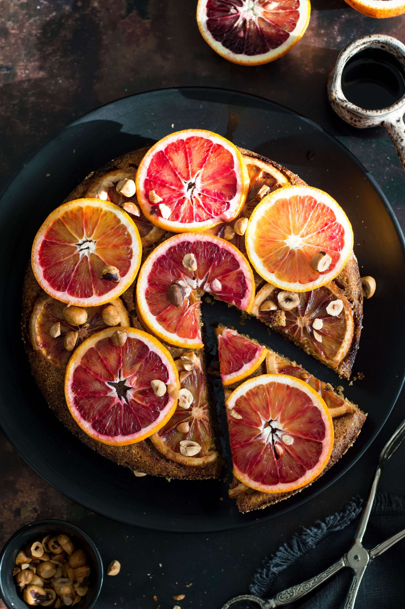 Top down view of upside down blood orange cake on a black plate
