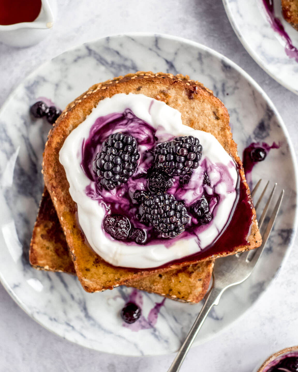 2 slices of Vegan French toast with yoghurt and berry compote on a grey plate 