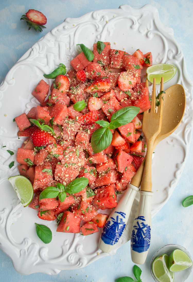 Top down view of Watermelon salad with vegan Parmesan on a white plate