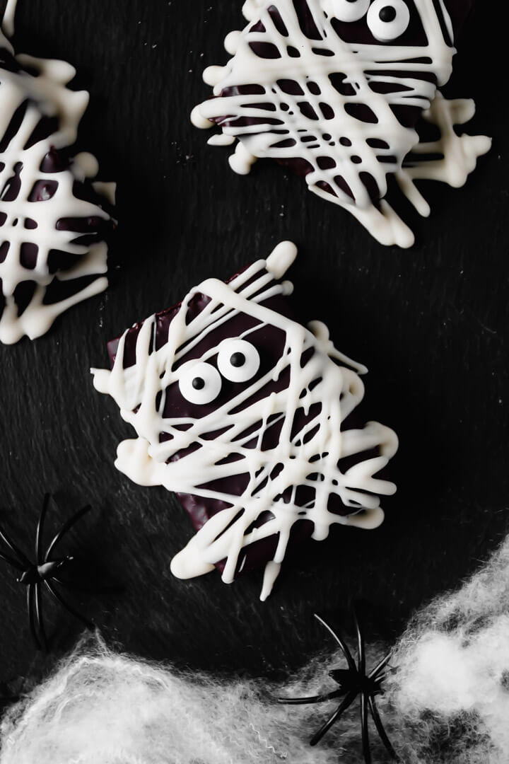 Top down view of spooky mummy chocolate bars on a black board 