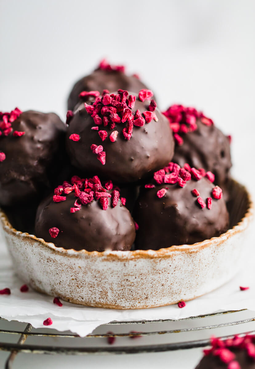 close up of chocolate date balls in a round dish 