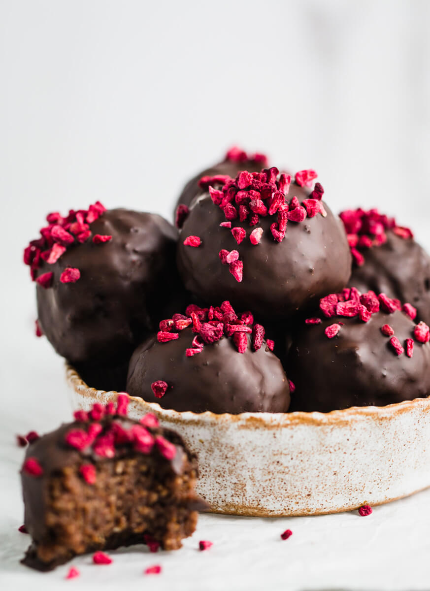 Close up of chocolate date balls in a round dish 