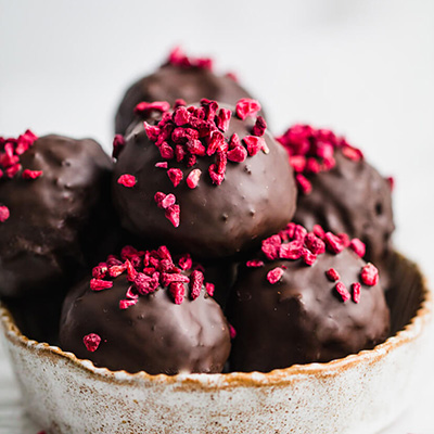 close up of chocolate date balls in a round dish