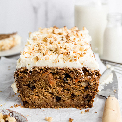 Close up view of a sliced vegan carrot cake loaf, knife on the side
