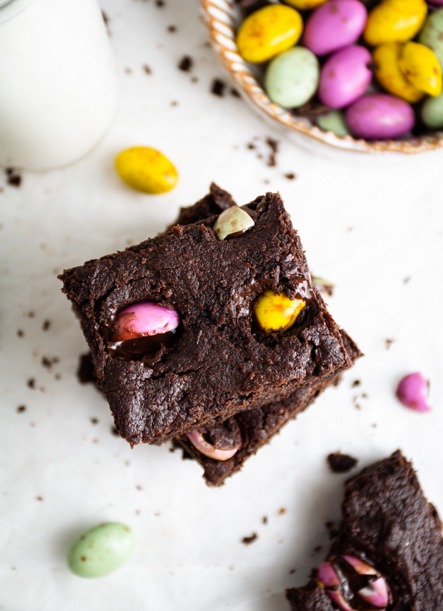 Top down view of vegan mini egg brownies, Easter chocolate eggs on the side