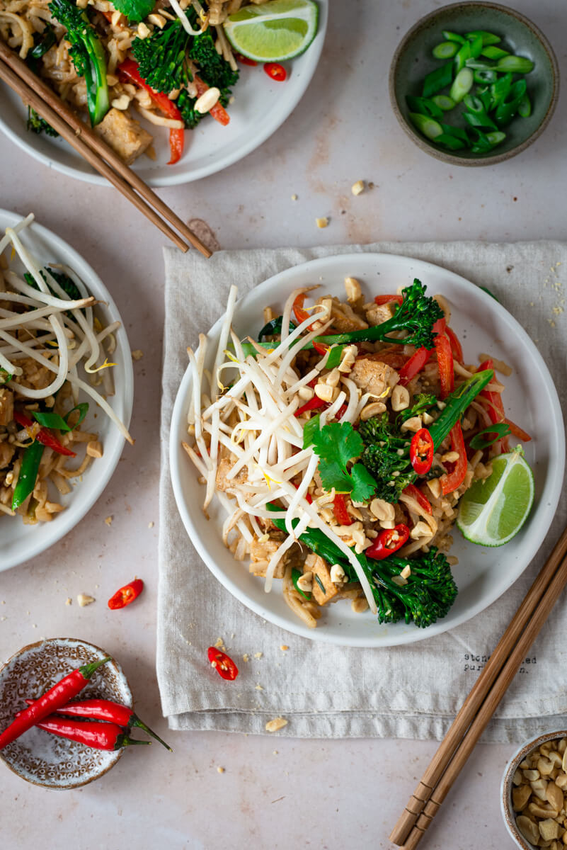 Vegan Pad Thai on a plate with lime wedges & broccoli