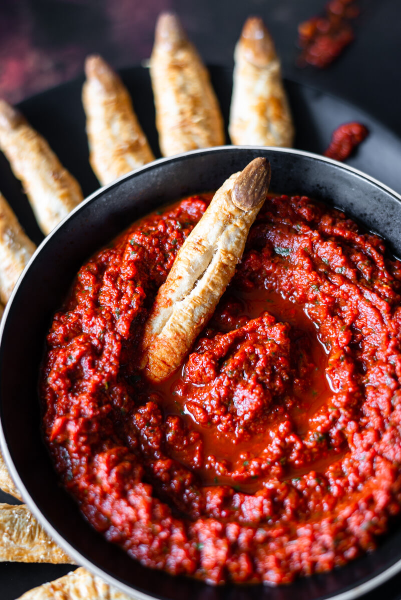 Witches’ finger breadsticks dipped into red pepper dip 