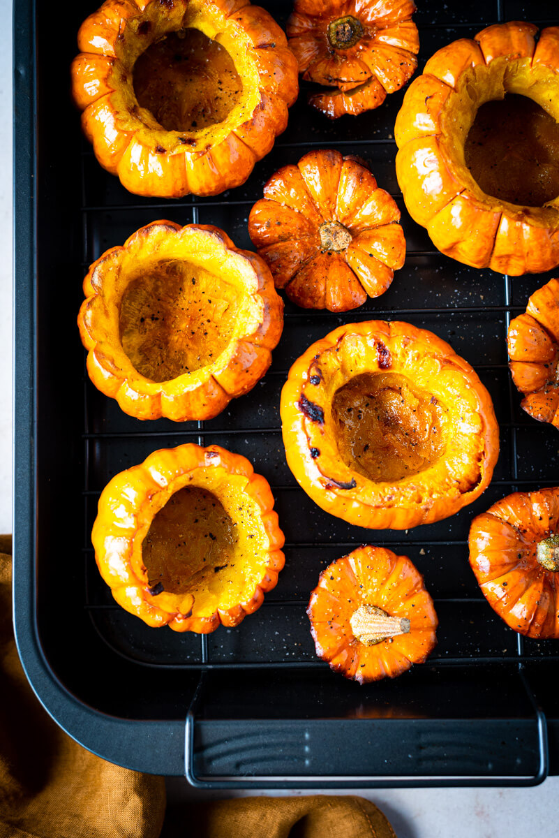 Top down view of roasted mini pumpkins on a roasting tray