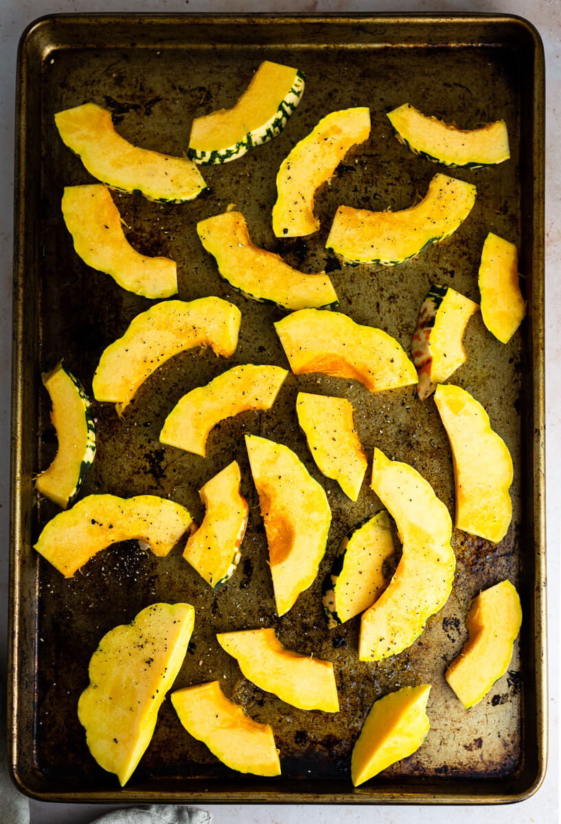 Top down view of cut up butternut squash on roasting tray